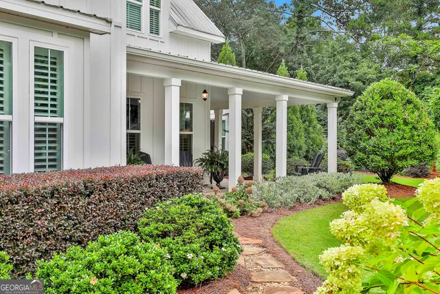 a kitchen with stainless steel appliances a dining table chairs a refrigerator and cabinets