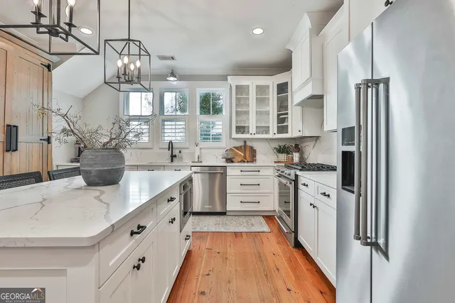 a living room with furniture a flat screen tv and a window