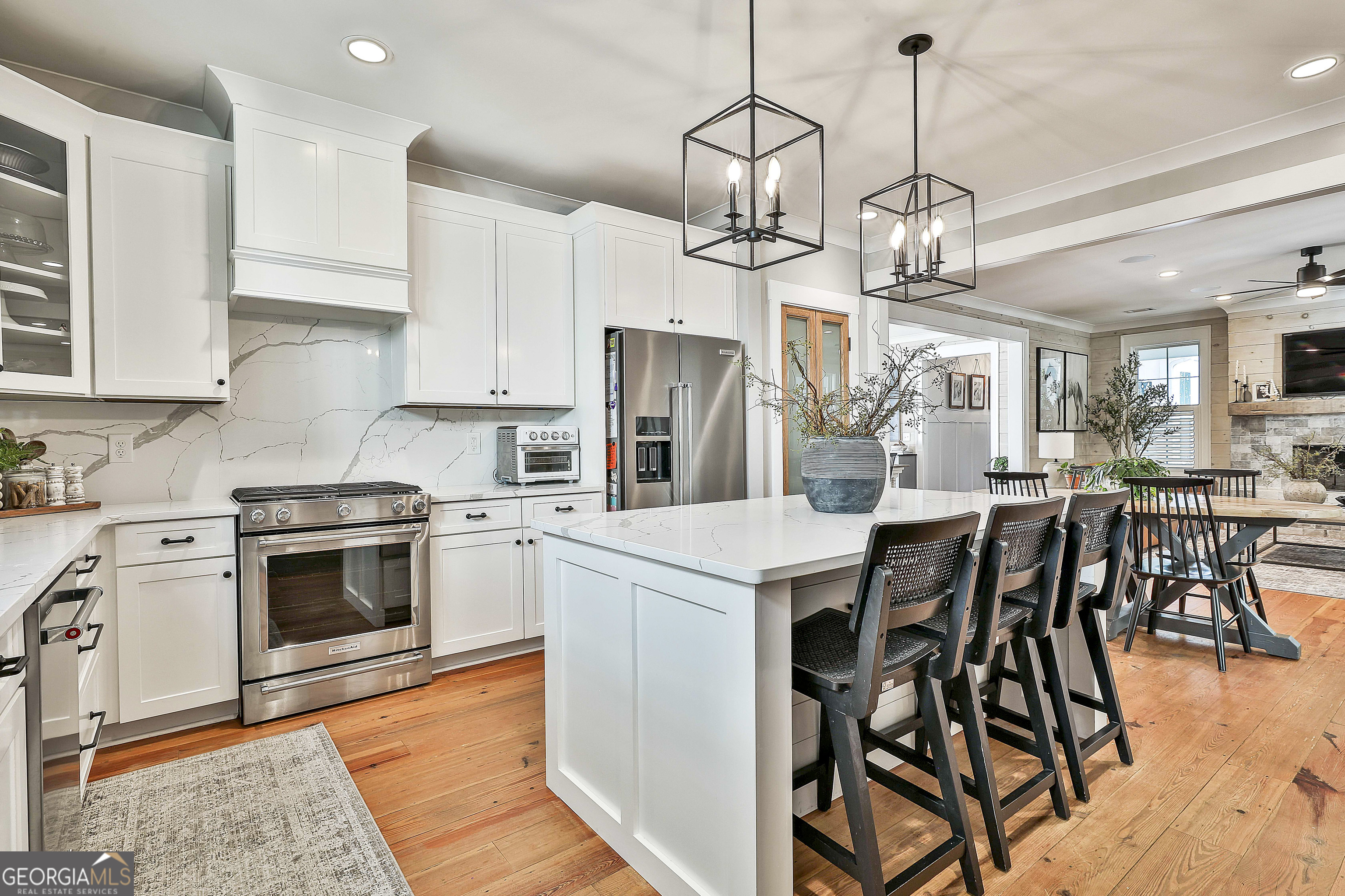 49 Standing Rock Road Senoia, GA 30276 - Photo 36 of 92 a kitchen with stainless steel appliances kitchen island granite countertop a table chairs in it and white cabinets