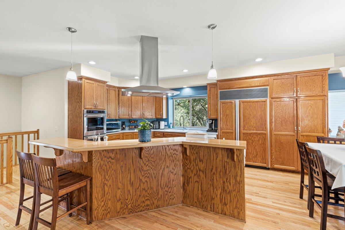 1144 Boole Road Applegate, CA 95703 - Photo 33 of 65 a view of a kitchen with kitchen island dining table and wooden floor