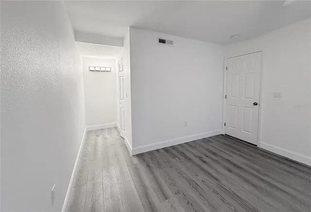 a view of a room with wooden floor and white doors