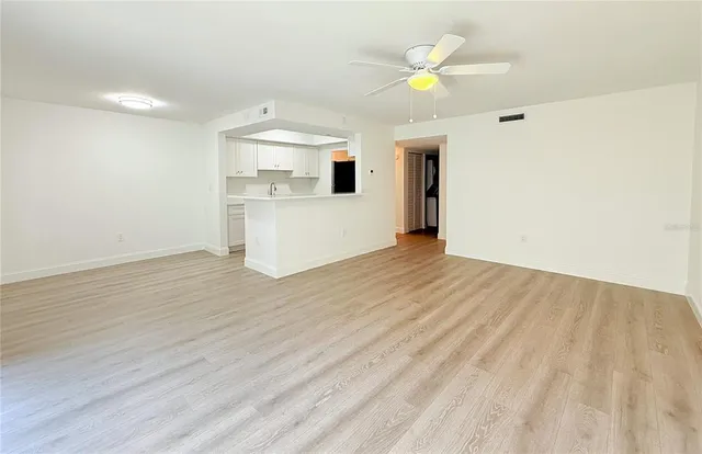 a view of a kitchen with wooden cabinet and a ceiling fan