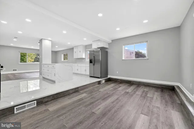 a view of empty room with wooden floor and window