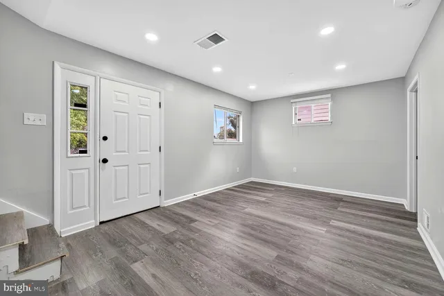a view of empty room with wooden floor