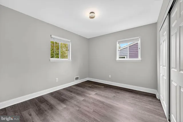 an empty room with a window and wooden floor