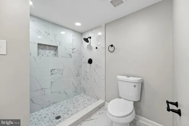 a white toilet sitting next to a bathroom sink