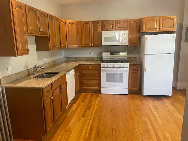 a kitchen with a sink a stove a refrigerator and cabinets
