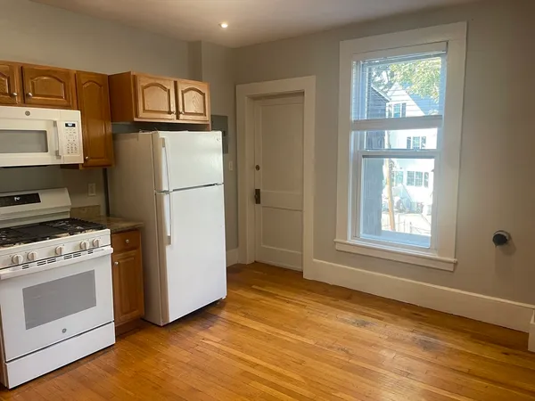 a white refrigerator freezer and a stove sitting inside of a kitchen