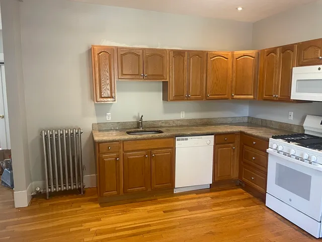 a kitchen with stainless steel appliances granite countertop a sink stove and cabinets