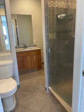 a bathroom with a granite countertop sink toilet and shower