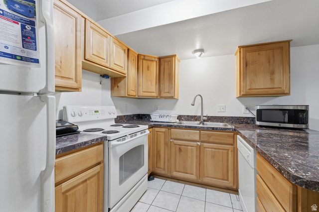 1700 Hickory Lane Provo, UT 84604 - Photo 13 of 20 Kitchen featuring wood-finish cabinetry, dark speckled countertops, and tile flooring