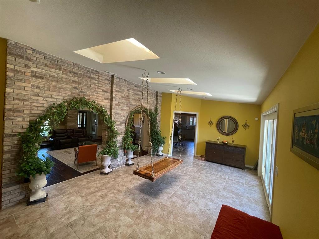 3612 Cross Bend Road Plano, TX 75023 - Photo 16 of 38 Living room featuring tile flooring, a skylight, and brick wall