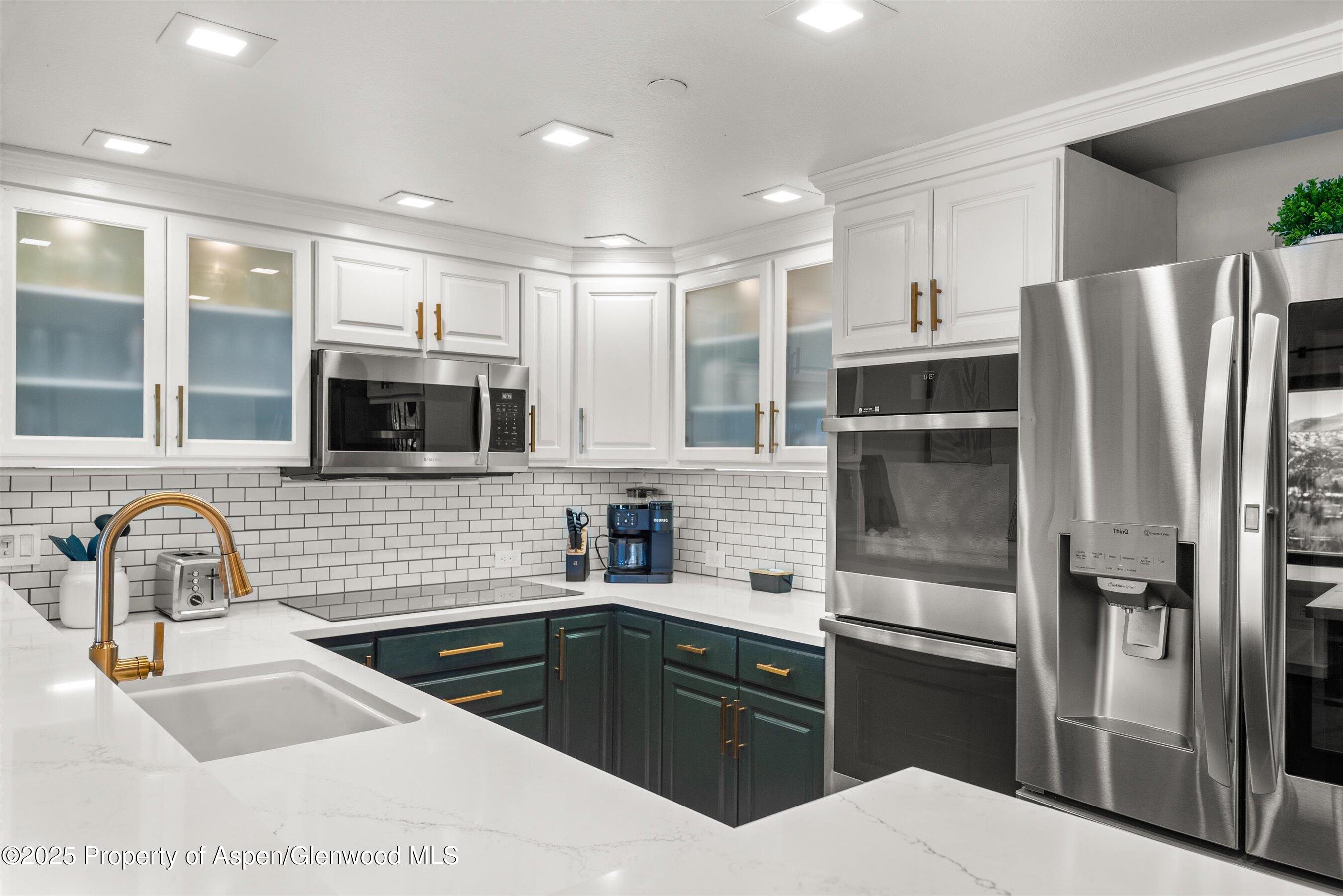 55 Upper Woodbridge Road, Unit J5 Snowmass Village, CO 81615 - Photo 11 of 32 a kitchen with granite countertop a refrigerator and a sink