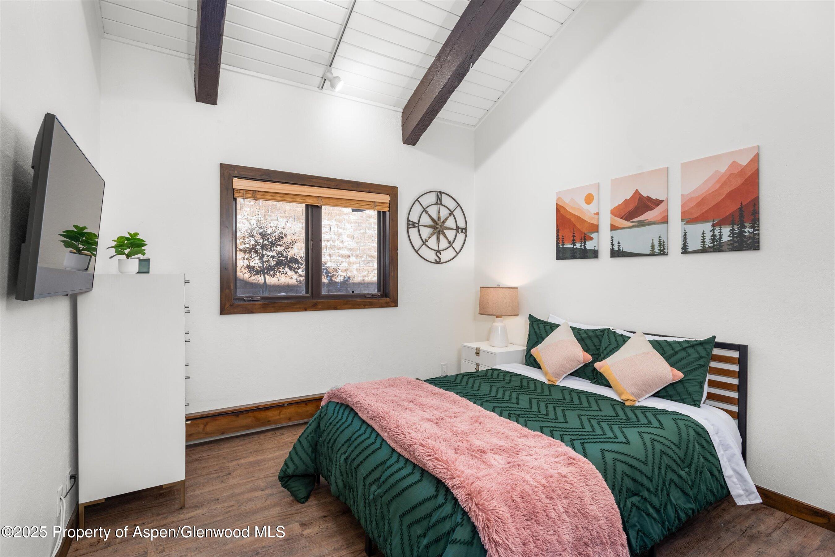 55 Upper Woodbridge Road, Unit J5 Snowmass Village, CO 81615 - Photo 17 of 32 a bedroom with a bed and a painting on the wall