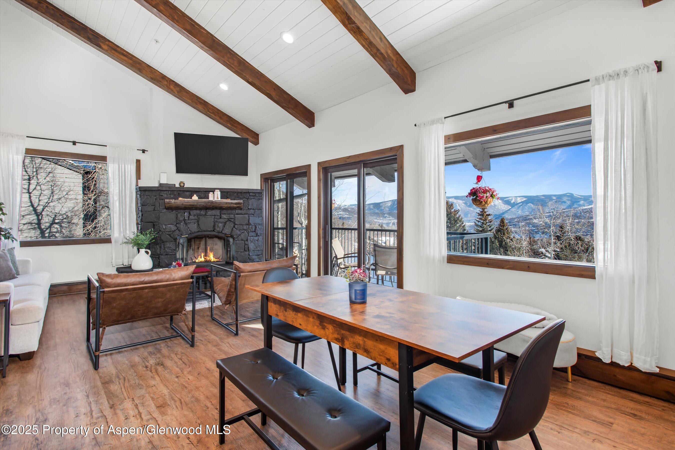 55 Upper Woodbridge Road, Unit J5 Snowmass Village, CO 81615 - Photo 3 of 32 a view of a dining room with furniture a fireplace and wooden floor
