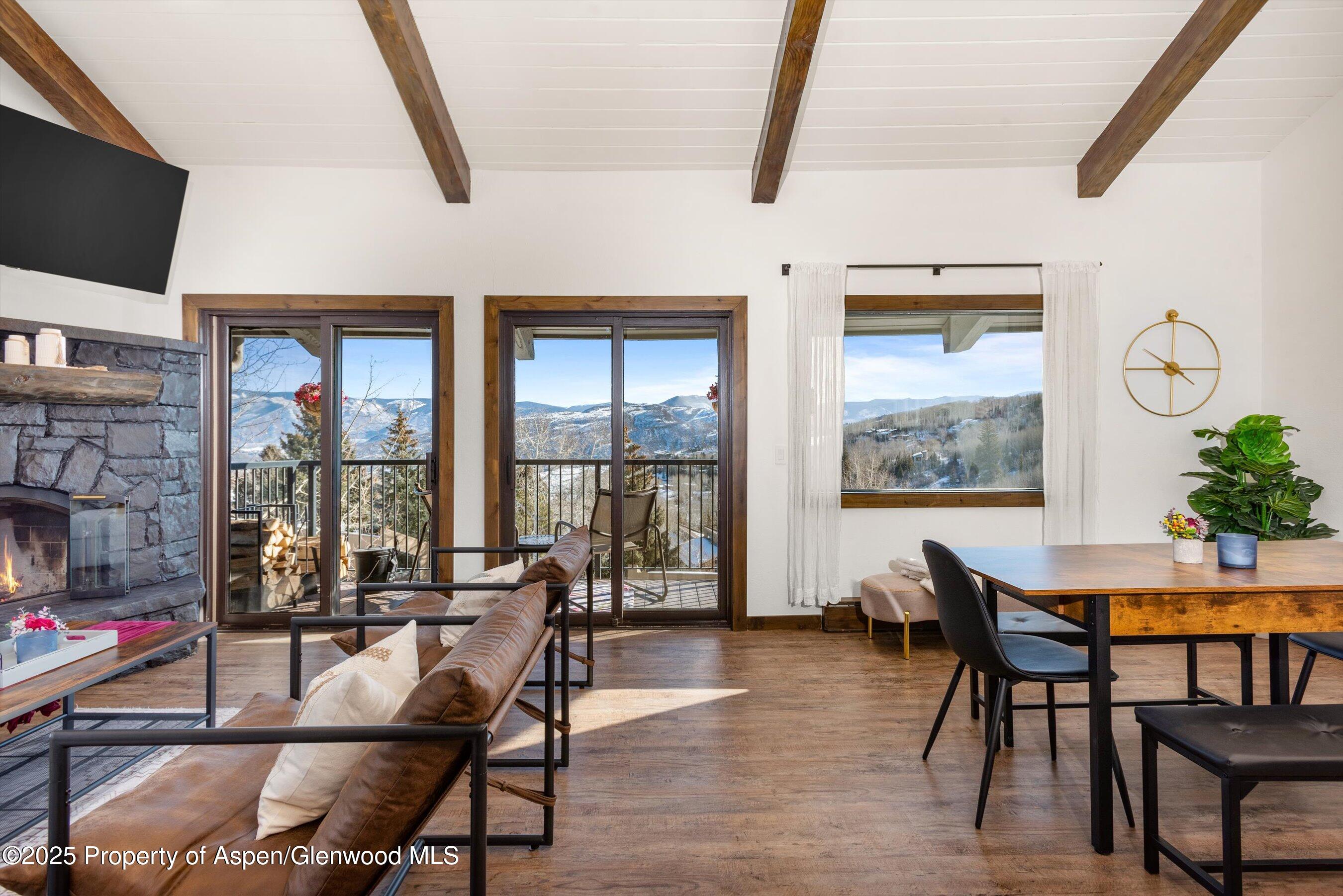 55 Upper Woodbridge Road, Unit J5 Snowmass Village, CO 81615 - Photo 6 of 32 a living room with furniture a flat screen tv and a floor to ceiling window