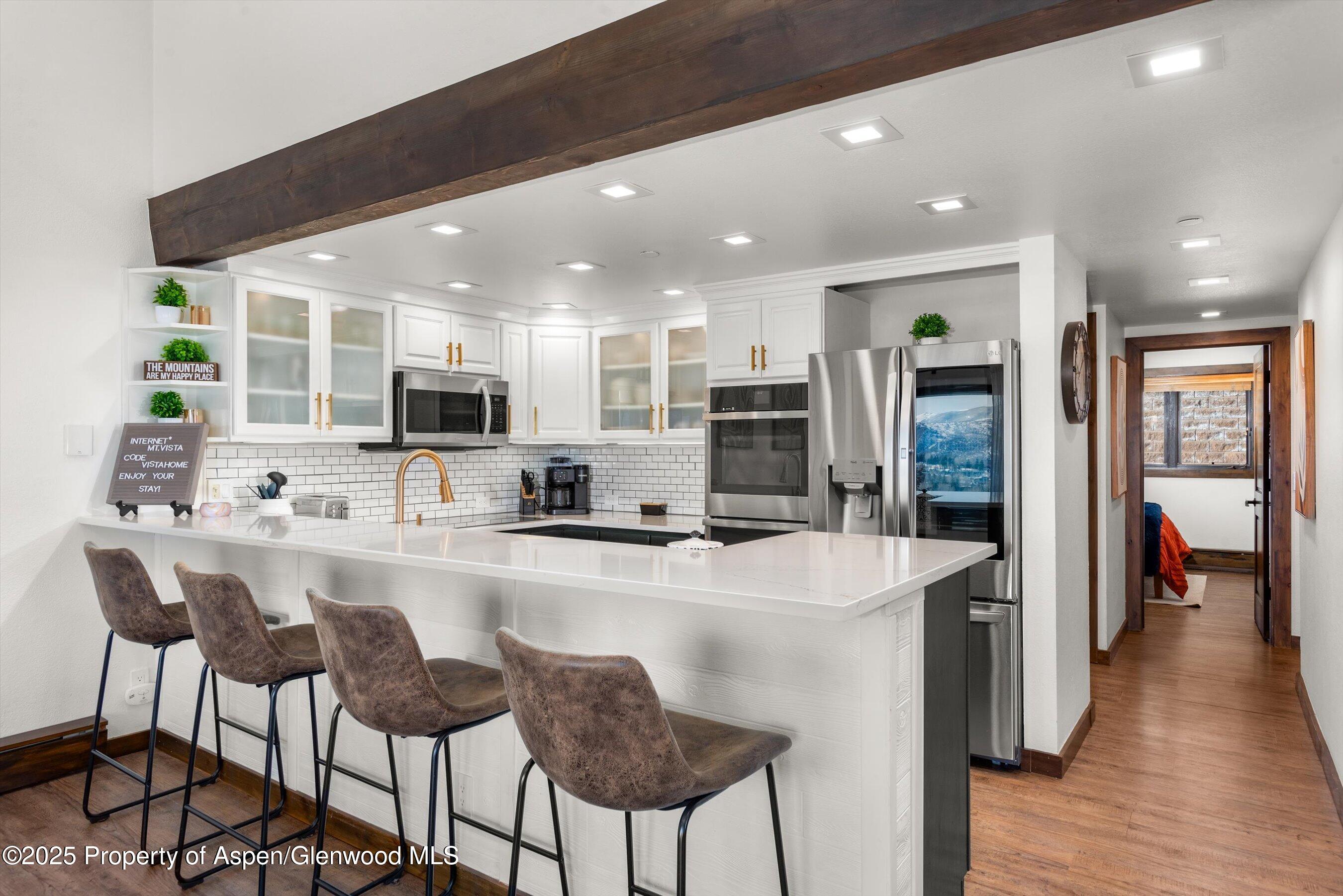 55 Upper Woodbridge Road, Unit J5 Snowmass Village, CO 81615 - Photo 9 of 32 a kitchen with stainless steel appliances kitchen island granite countertop a sink and cabinets