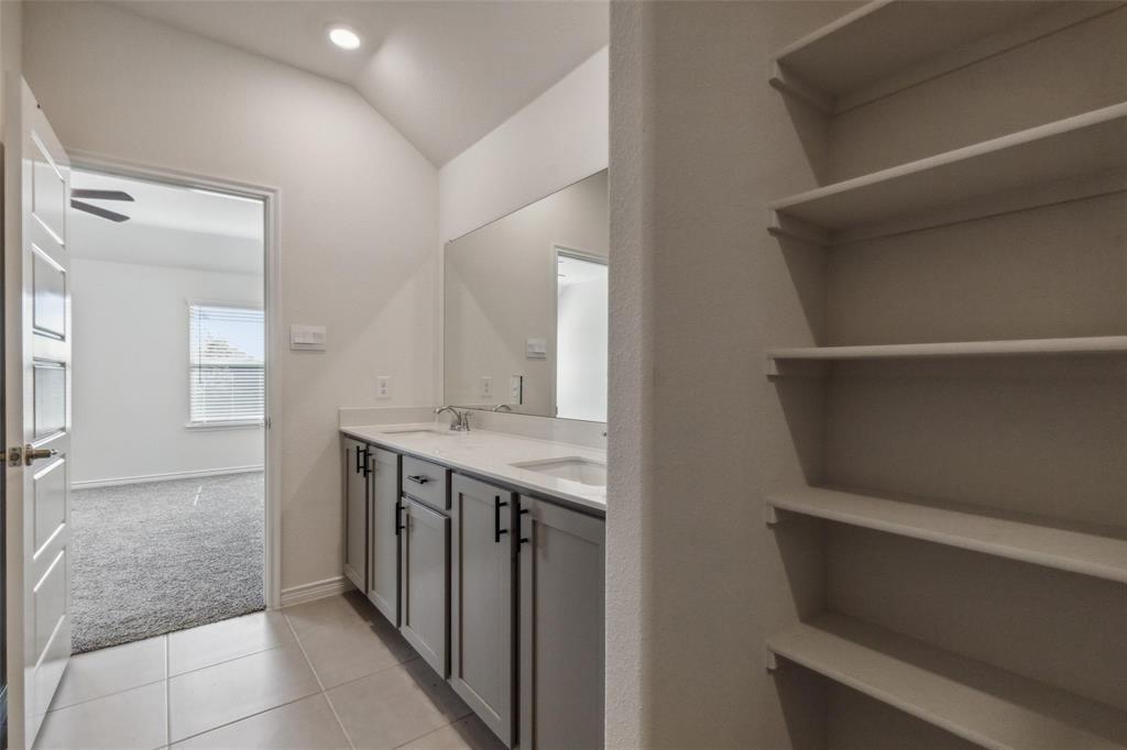 10314 Echo Brk Lane Aubrey, TX 76227 - Photo 8 of 21 Bathroom featuring double vanity, light tile patterned floors, light carpet, and vaulted ceiling