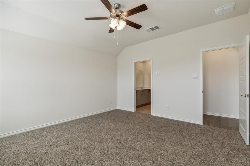 10314 Echo Brk Lane Aubrey, TX 76227 - Photo 9 of 21 Unfurnished bedroom with carpet flooring, connected bathroom, vaulted ceiling, and a ceiling fan