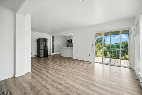 a view of empty room with wooden floor and floor to ceiling window