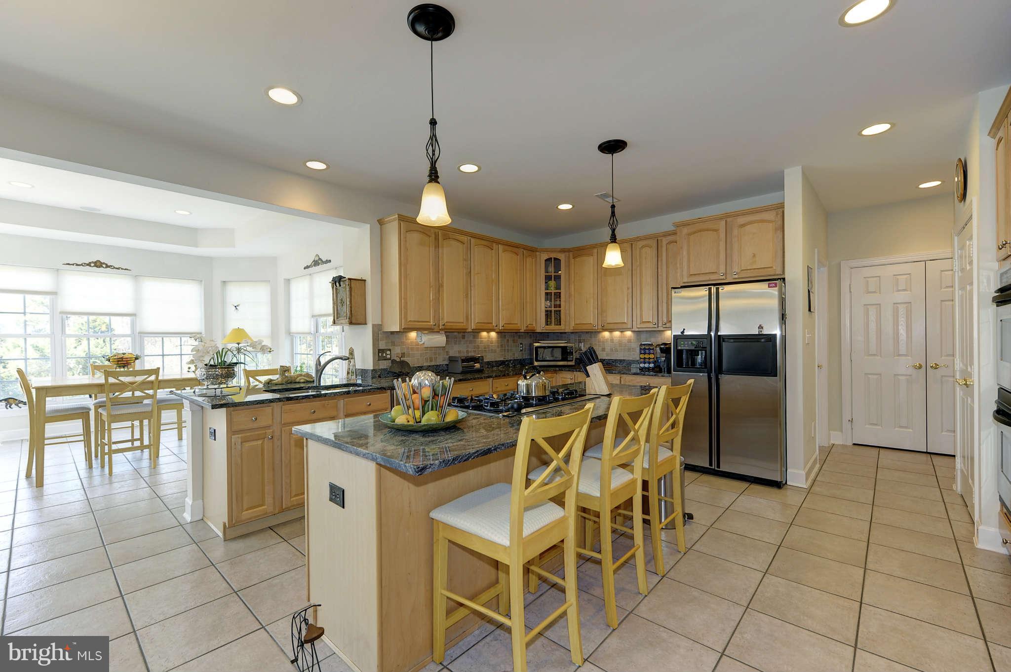 10404 Grey Fox Road Potomac, MD 20854 - Photo 10 of 30 a kitchen with stainless steel appliances granite countertop a stove top oven a sink a dining table and chairs