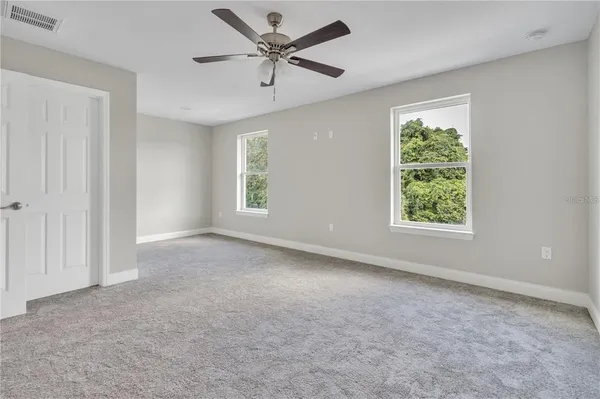 an empty room with a window and a fan