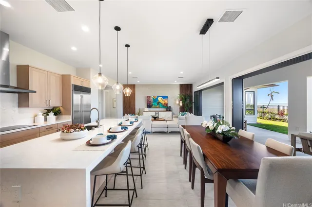 a view of a dining room and livingroom with furniture wooden floor a rug a fireplace and a chandelier
