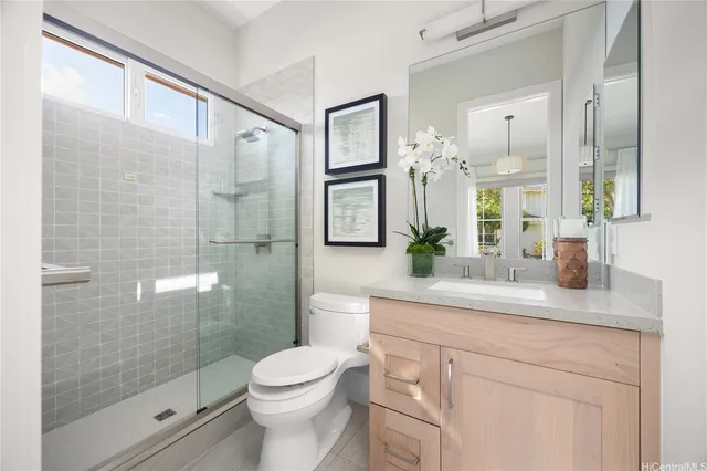 a bathroom with a granite countertop sink a toilet and shower