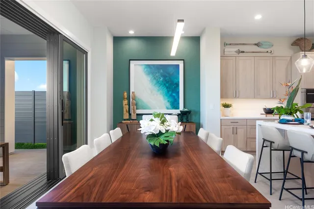 a view of a dining room with furniture a potted plant and wooden floor