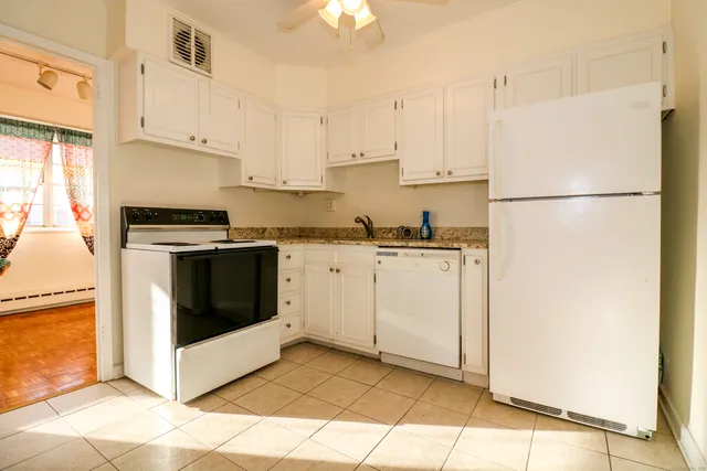 a kitchen with white cabinets and white appliances