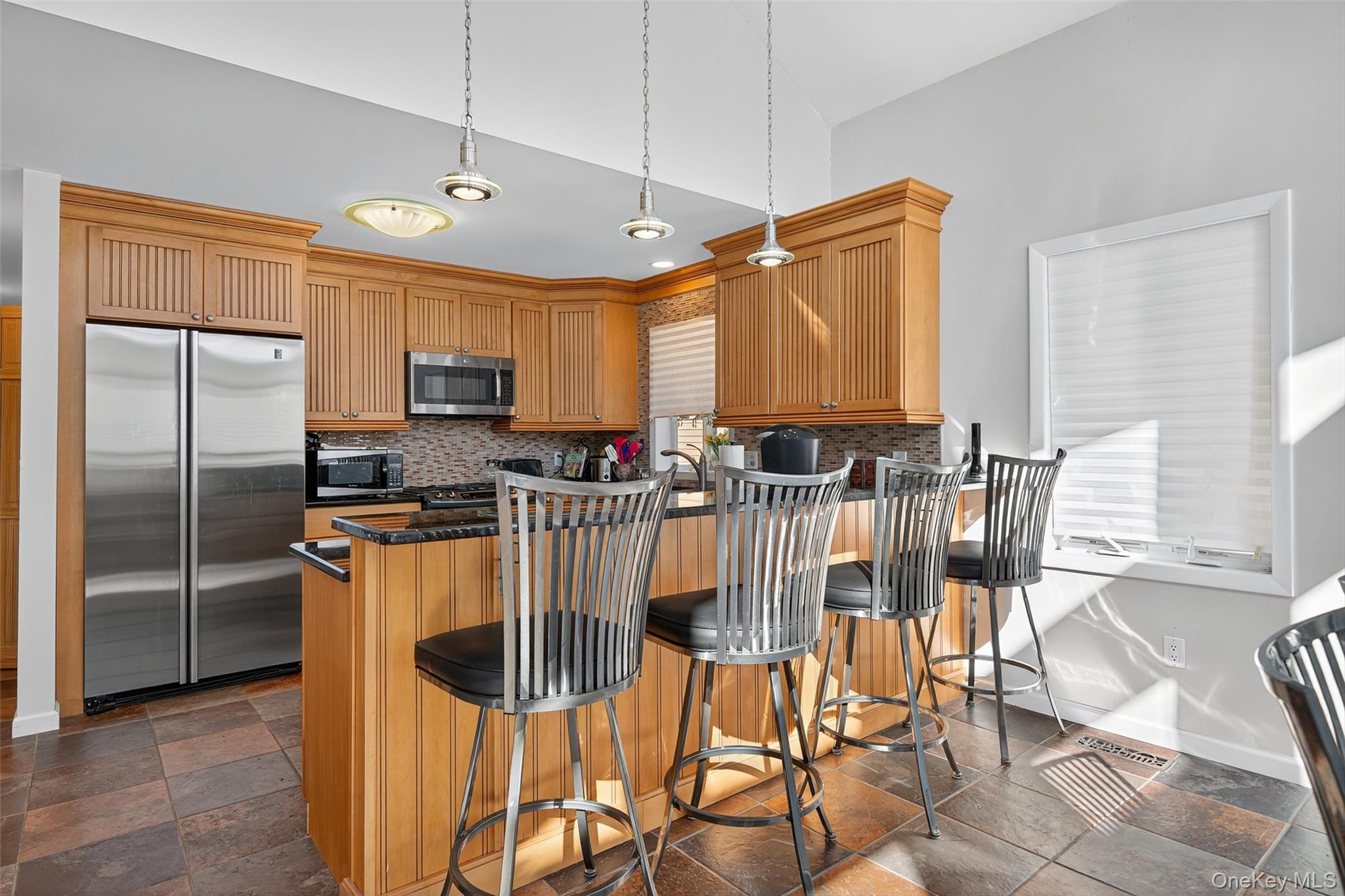 518 Sackett Lake Road Monticello, NY 12701 - Photo 11 of 44 a kitchen with stainless steel appliances kitchen island granite countertop a refrigerator a stove a sink a dining table and chairs with wooden floor