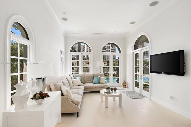 a living room with furniture a flat screen tv and a floor to ceiling window