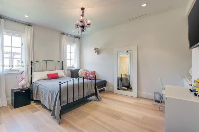 a bedroom with a large bed and a chandelier