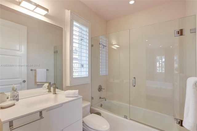 a view of a swimming pool with a lawn chairs under palm trees