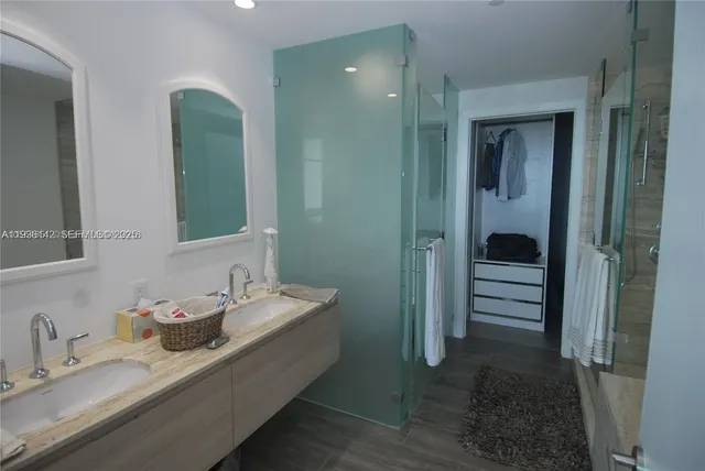 a bathroom with double vanity sinks and a mirror