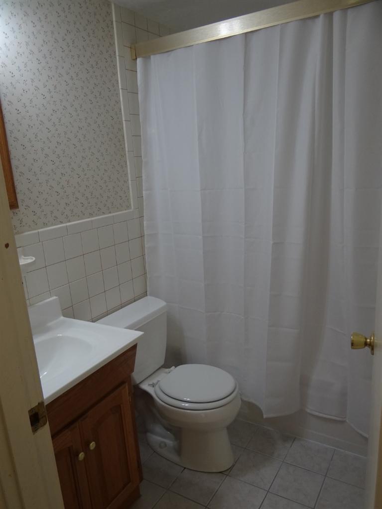 22 Millbrook Road Bourne, MA 02532 - Photo 13 of 25 a white toilet sitting next to a shower curtain
