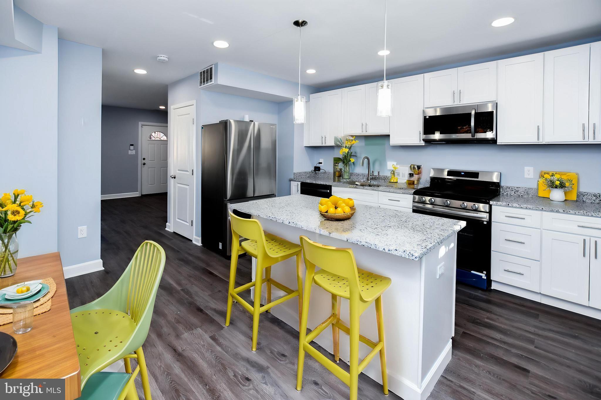 a kitchen with a sink a stove a kitchen island and chairs