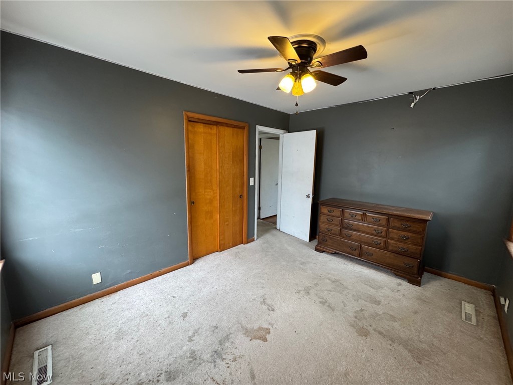 3828 Lake Road West Ashtabula, OH 44004 - Photo 12 of 29 Unfurnished bedroom with carpet floors, a ceiling fan, and a closet