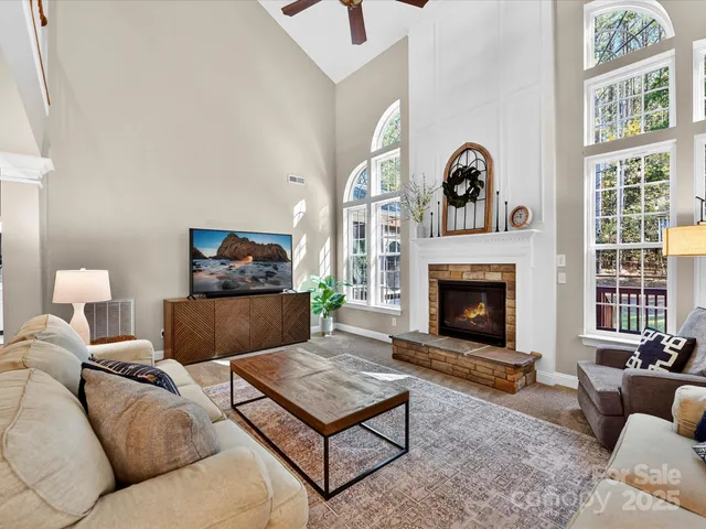 a living room with furniture a flat screen tv and a fireplace