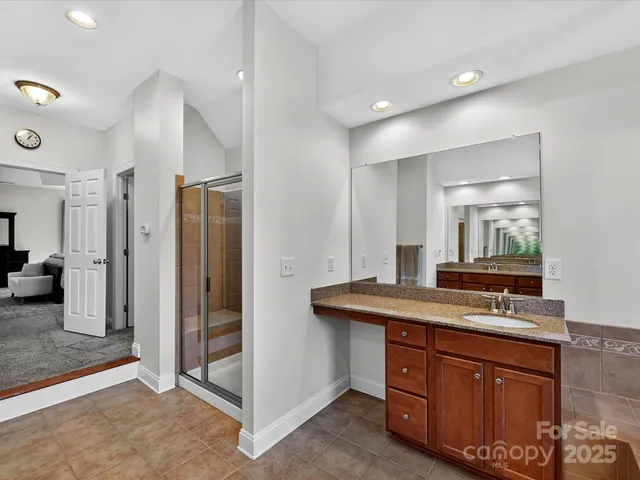 a bathroom with a granite countertop sink and a mirror
