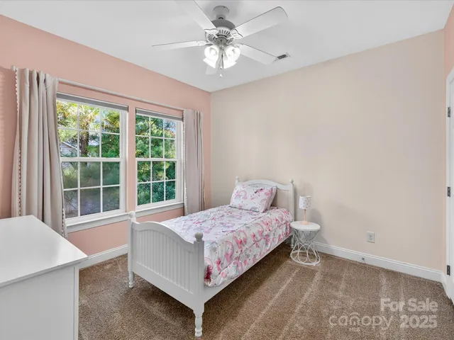 a bedroom with a bed and a large window with the outer view