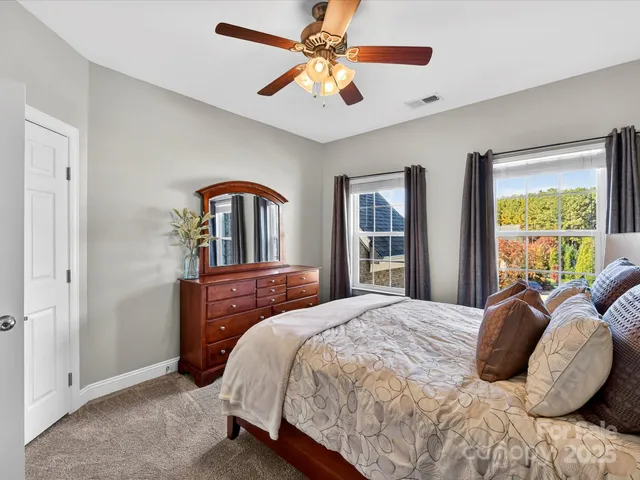 a bedroom with a large bed and a chandelier