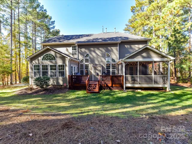 a view of a house with a big yard and large trees