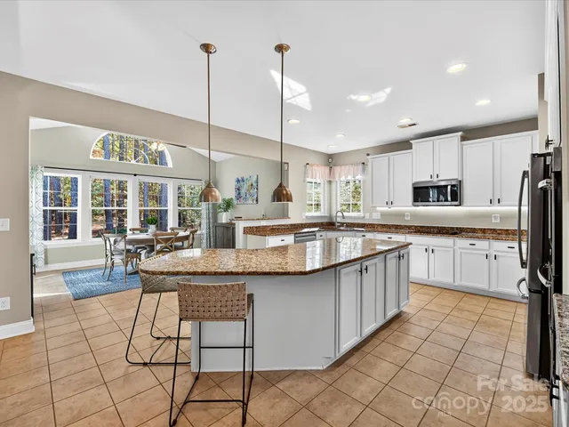 a kitchen with stainless steel appliances kitchen island granite countertop a sink and cabinets