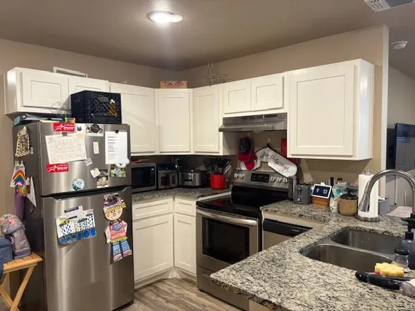 a bathroom with a granite countertop sink and a toilet
