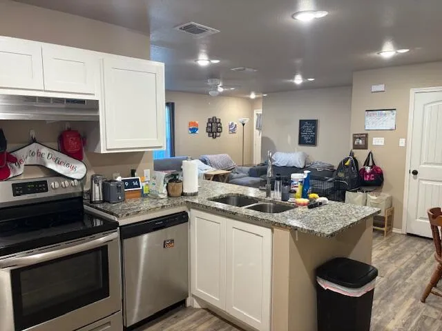 a bathroom with a granite countertop sink and a toilet