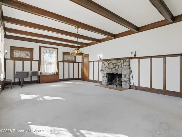 a view of an empty room with a fireplace and a window