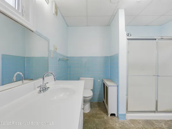 a bathroom with a sink a toilet and shower