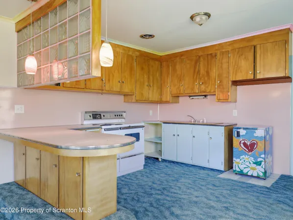 a kitchen with a sink a stove cabinets and wooden floor