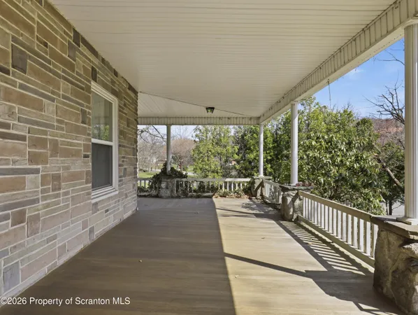 a view of a porch with wooden floor and furniture